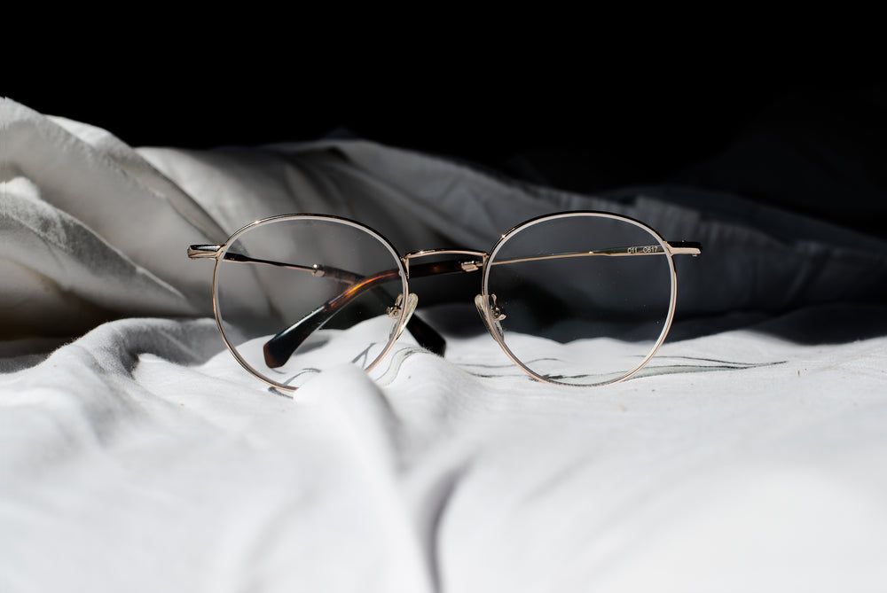 pair-of-glasses-on-a-bed
